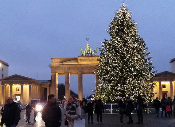 Weihnachtsbaum mit leuchtenden Lichtern vor dem Brandenburger Tor in Berlin